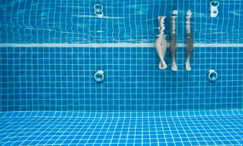 Funny underwater family legs in swimming pool, vacation and sport concept